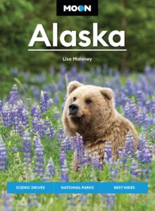 Image of grizzly bear in meadow of purple flowers with text reading Moon Alaska