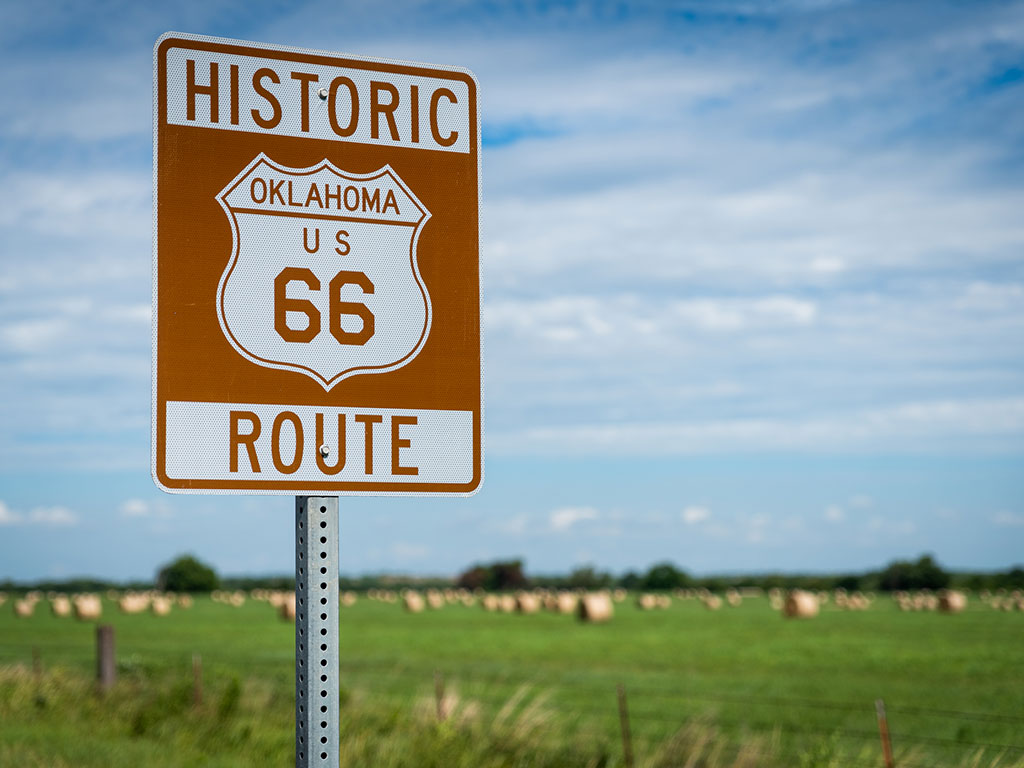 historic route 66 sign with oklahoma farmland in the background