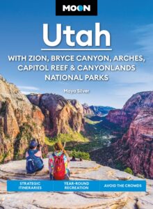 Book jacket featuring image of hikers on a cliff overlooking a valley with text Moon Utah